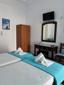 佩里萨Anna Maria Rooms Santorini的带镜子的客房内的两张单人床