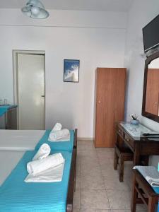 佩里萨Anna Maria Rooms Santorini的客房设有两张床、一个水槽和一张书桌