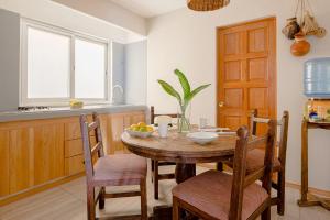 瓦哈卡市Suites Parador Santo Domingo de G.的厨房配有木桌和椅子