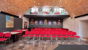 扎莫希奇Hotel77的大楼内一间设有红色椅子和桌子的房间