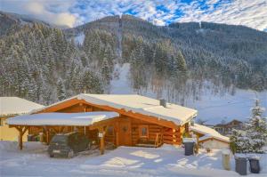 滨湖采尔Chalet Stabler - by Alpen Apartments的小木屋,屋顶上积雪