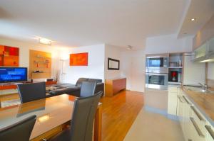 滨湖采尔Apartment Leon - by Alpen Apartments的厨房以及带桌椅的起居室。