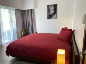 圣斐利-银港Picturesque Ocean View Condo的一间卧室配有一张红色床罩的床
