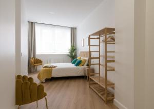 毕尔巴鄂KAIXO BILBAO APARTMENTS的一间卧室配有一张床和一张双层床梯