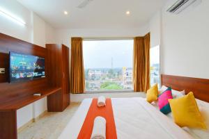 耶拉汉卡Keerthis Royal Suites Kempegowda International Airport的一间卧室设有一张大床和大窗户