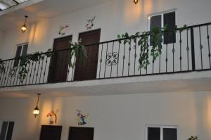 TararameoMia Bonita Hotel Boutique的白色的房子,阳台上种植了植物