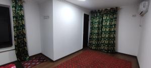 布哈拉Diyor Hostel的一间红色地毯、窗帘和门的房间