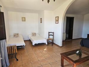 TorilHotel Rural Portilla de Monfragüe的一间设有两张床和一张桌子的房间