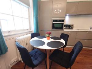 伦敦Kings Cross Apartment的厨房配有桌子、椅子和桌子
