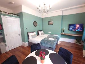 伦敦Kings Cross Apartment的一间卧室配有两张床和一张桌子及椅子