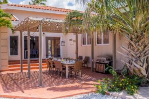 棕榈滩Villa Bubali Escape的一个带桌椅和烧烤架的庭院