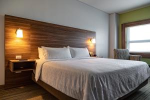 恩塞纳达港Holiday Inn Express & Suites - Ensenada Centro, an IHG Hotel的一间卧室配有一张大床和木制床头板