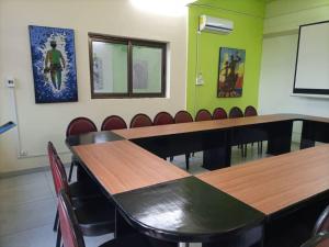 博博迪乌拉Oasis Lawafossi的一间会议室,配有木桌和椅子
