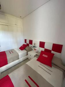 米迪克Lilacs Garden Cabo的一间卧室配有两张带红白色枕头的床