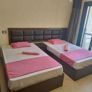 沙姆沙伊赫Juliee House-Criss Resort-Naama Bay的配有粉红色床单的客房内的两张床
