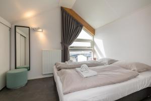 雷讷瑟Strandvilla 30 Renesse的卧室配有一张大白色床和窗户