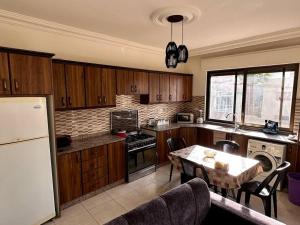 马达巴4 Bedroom Flat in Madaba with AC的厨房配有木制橱柜、餐桌和用餐室