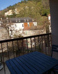 韦尔内莱班Studio Soleil Vernet的阳台的蓝色野餐桌,与大楼相连