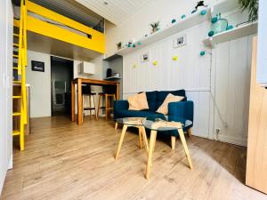 莱萨布勒-多洛讷L Appart’ Grande Plage的客厅配有蓝色的沙发和桌子