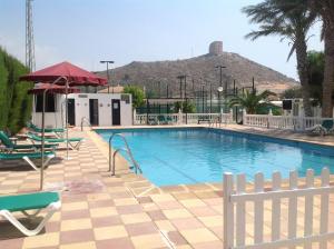 费罗堡Hotel Iberico的一个带椅子的游泳池,后方是一座山。