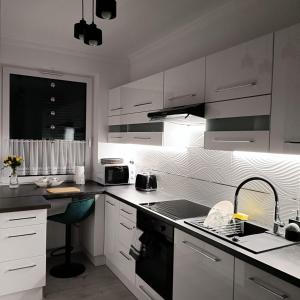 尼萨BELWEDER的厨房配有白色橱柜和黑炉灶烤箱。