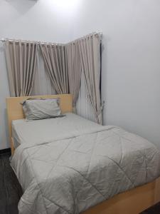 日惹Anyak's place Syariah的卧室内的一张带灰色棉被的床
