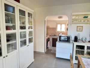 奥尔贝泰洛CASA IL PINO的厨房配有白色橱柜和微波炉