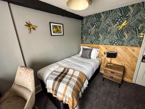 索尔兹伯里老磨房酒店的一间小卧室,配有一张床和一把椅子