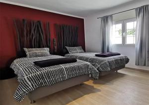 瓜蒂萨Casa Helena del Mar的红色墙壁的客房内的两张床