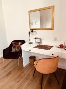 勒法韦La Maison de Louisette的一张带镜子和椅子的白色书桌