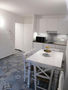 奥尔戈索洛Locanda B&B Dandana的白色的厨房配有白色的桌子和椅子