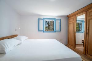 纳乌萨Kolimpithres beach house的卧室配有白色的床和窗户。