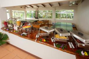 别霍港Manzanillo Caribbean Resort的一间大厨房,配有几张带食物的自助餐桌