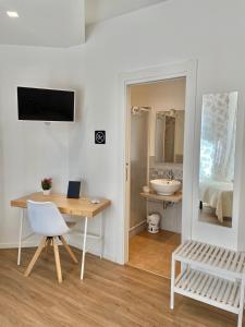 阿尔盖罗Catalogna10 Rooms的客房设有书桌、桌子和镜子