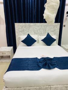 基苏木SR Apartments Milimani, Kisumu的一张带蓝色枕头的白色床和蓝色弓领