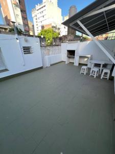 罗萨里奥El pasillo Centro的大楼内的阳台配有白色的桌椅