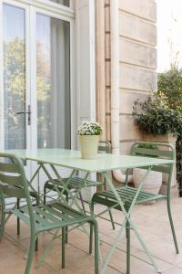 阿尔勒Maison Douce Arles的天井上摆放着绿色的桌椅