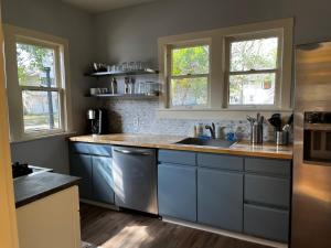 莱克兰Southern Charm in Lakeland的厨房配有蓝色橱柜、水槽和2扇窗户。