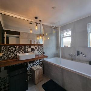 赫曼努斯Kwikstertjie的带浴缸、水槽和镜子的浴室
