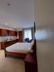 MbaleLe Cottage Mbale的酒店客房带一张床和一个厨房