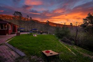 North ForkSierra Vista Lookout Lodge with Creek, Waterfall and Waterholes, minutes from Bass Lake and Yosemite South Gate的草地上带桌子的田野,日落