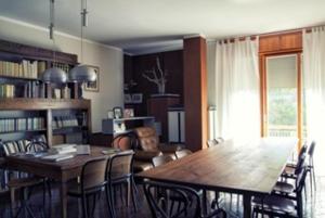 里米尼卡萨曼奇尼住宿加早餐旅馆的一间带木桌和椅子的用餐室