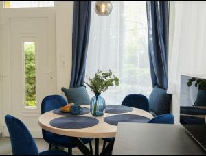 布达佩斯Blue Bird Citadel Apartment的一间带桌子和蓝色椅子的用餐室