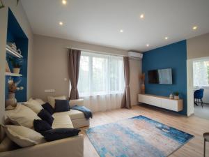 布达佩斯Blue Bird Citadel Apartment的客厅设有白色沙发和蓝色的墙壁。