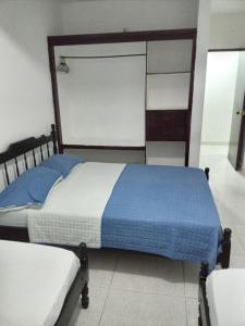 卡塔赫纳Hotel Rosandy Galaxy的一间卧室配有蓝色和白色床单