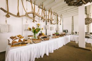 圣安娜纳克索斯磨坊风车酒店的一张长桌,上面有食物,放在白色的房间