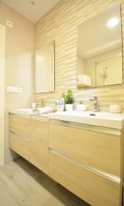 桑亨霍Apartamento en pleno centro de Portonovo, Sanxenxo的一间带两个盥洗盆和大镜子的浴室