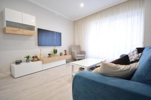 桑亨霍Apartamento en pleno centro de Portonovo, Sanxenxo的客厅配有蓝色的沙发和电视
