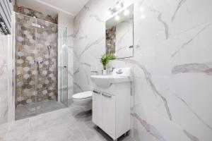 尼彻兹Polanka Apartamenty的白色的浴室设有卫生间水槽和淋浴。