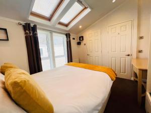 Saint Helens2 Bedroom Lodge TH35, Nodes Point, St Helens, Isle of Wight的卧室设有一张白色大床和一扇窗户。